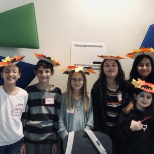 Five students showing off their Thanksgiving hats they made of construction paper