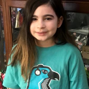SDPA GIRL STUDENT WEARING A LOGO SHIRT OF A HAWK IN FRONT. T-SHIRT COLOR TURQUOISE.